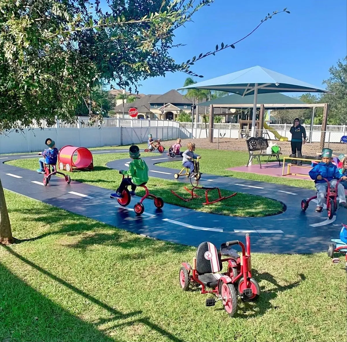 Children riding trikes on the painted Bike Trail at Primavera Preschool